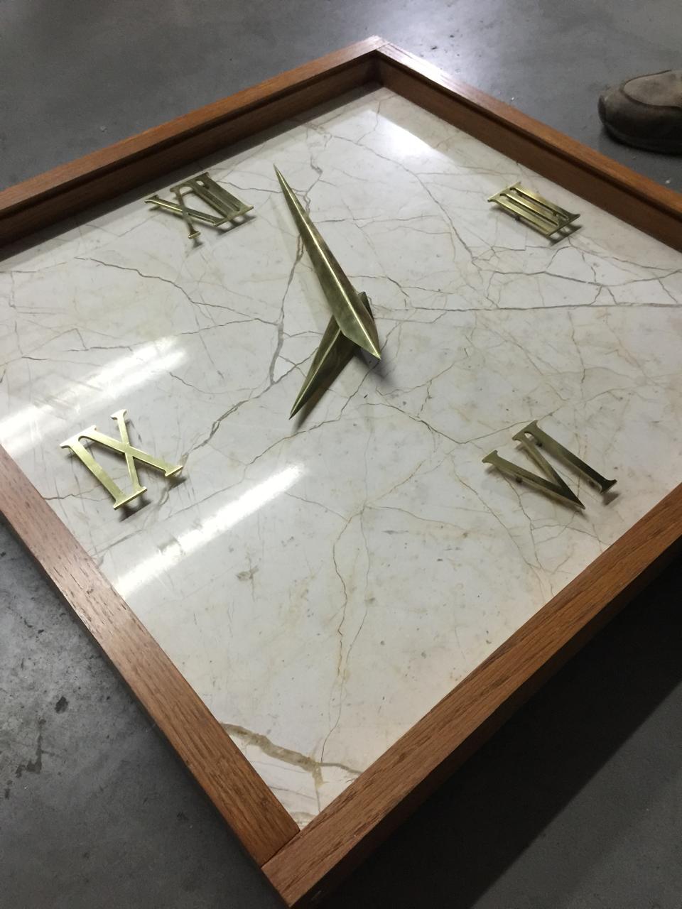 Reloj de mármol con numerales romanos de latón en marco de madera