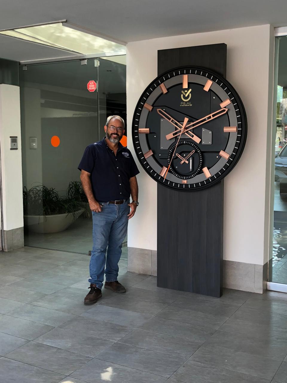 Reloj de pedestal con esfera negra e índices de cobre